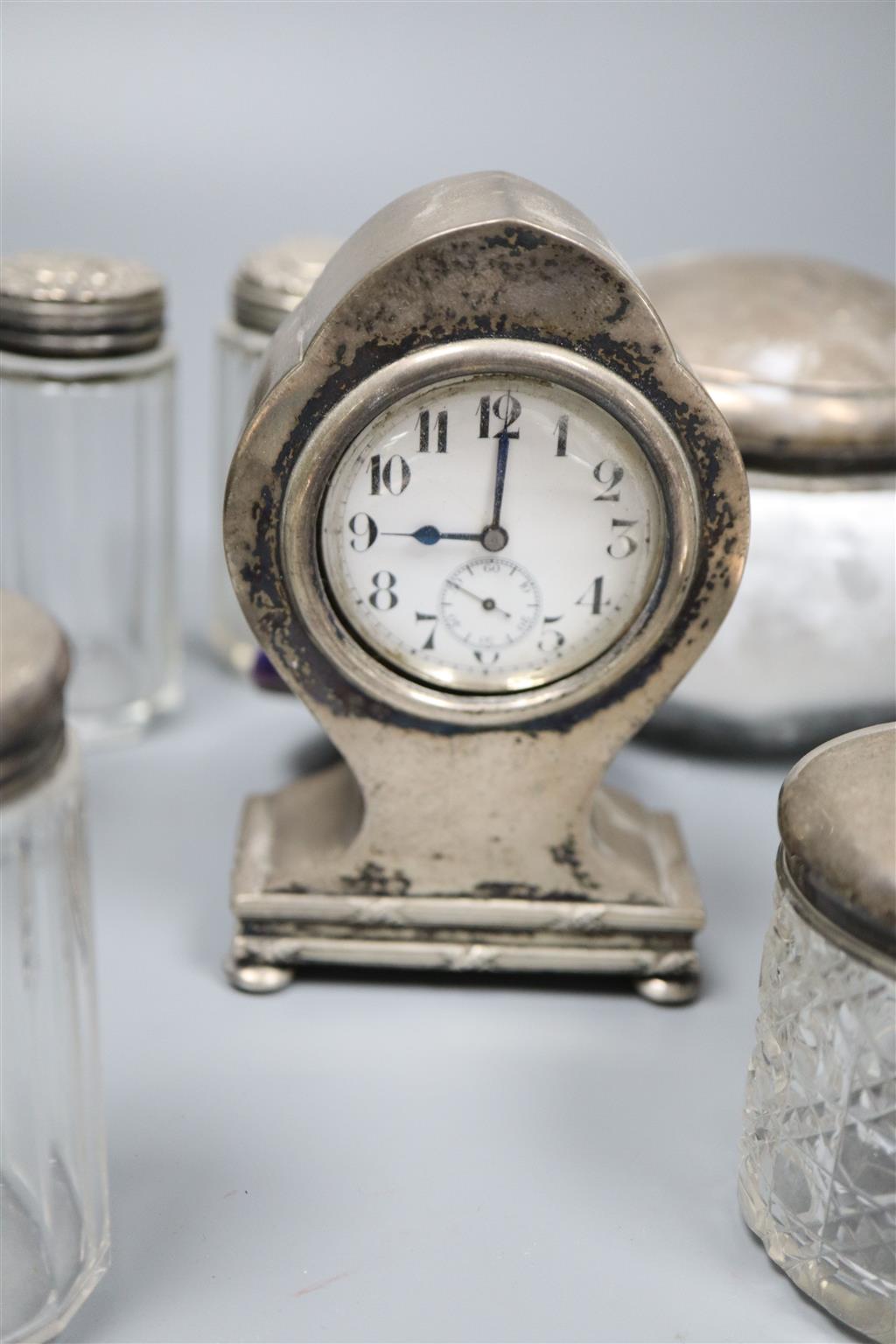 An Edwardian silver mounted balloon shaped timepiece, 11.5cm and sundry mounted toilet jars.
